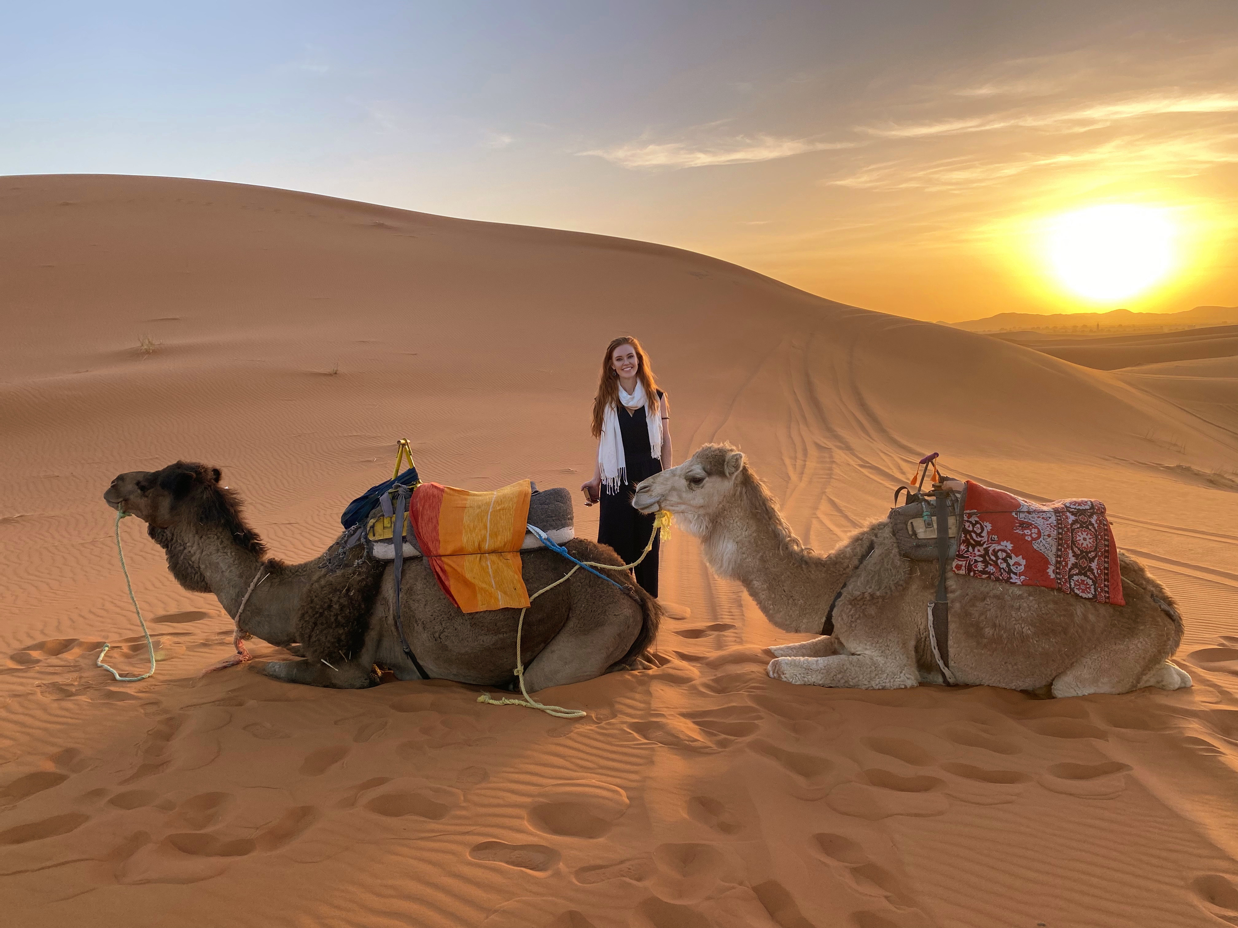 Crystal OGuin with two camels in the desert sunset